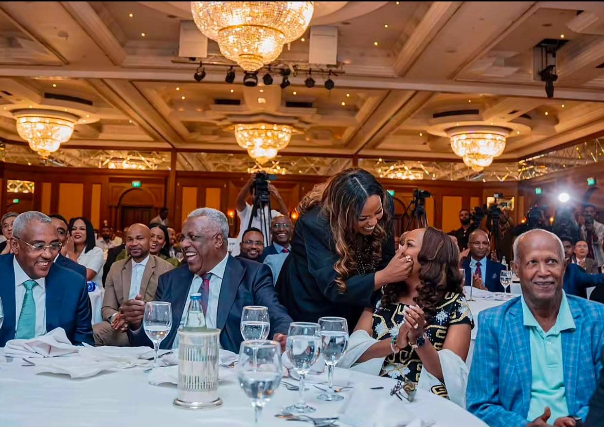 Guests laughing at a gala dinner table under the ballroom chandeliers